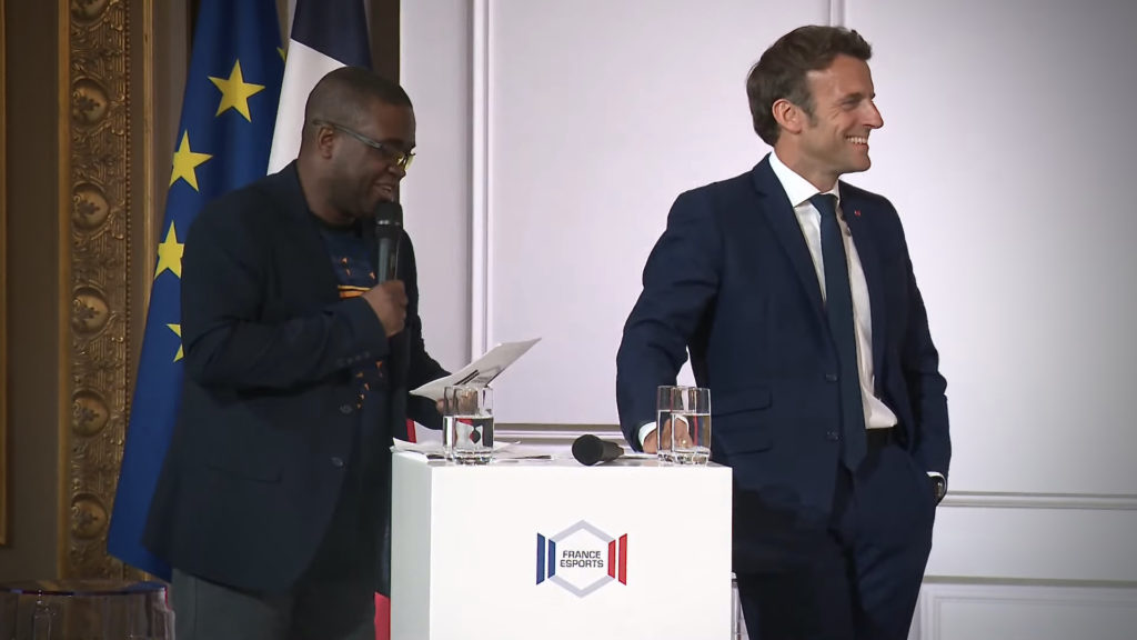 Le président de France esports parle au micro alors que Macron regarde hors de la scène