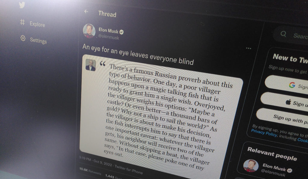 Screenshot of an October 2022 tweet from Elon Musk "An eye for an eye leaves everyone blind" with an image with the quote: There's a famous Russian proverb about this type of behavior. One day, a poor villager happens upon a magic talking fish that is ready to grant him a single wish. Overjoyed, the villager weighs his options: "Maybe a castle? Or even better-a thousand bars of gold? Why not a ship to sail the world?" As the villager is about to make his decision, the villager is about to say that there is one important caveat: whatever the villager gets, his neighbor will receive two of the same. Without skipping a beat, the villager says, "In that case, please poke one of my eyes out.