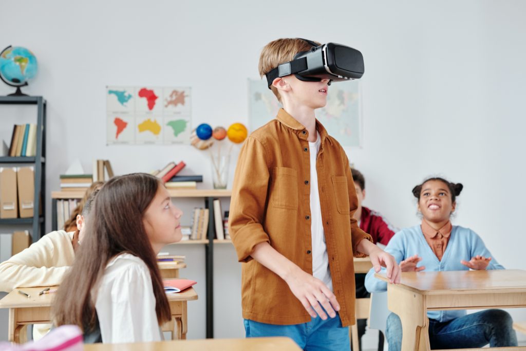 Un enfant avec un casque de réalité virtuel dans une salle de classe